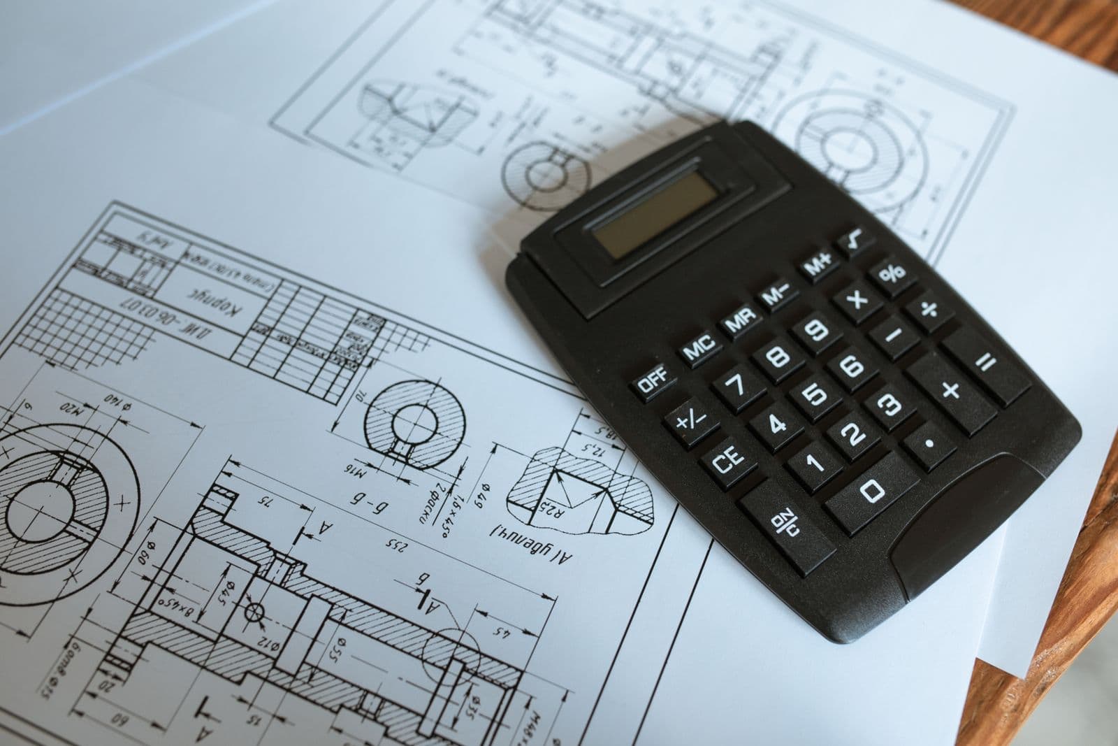 Rekenmachine op technische tekeningen voor het berekenen van bouwkosten